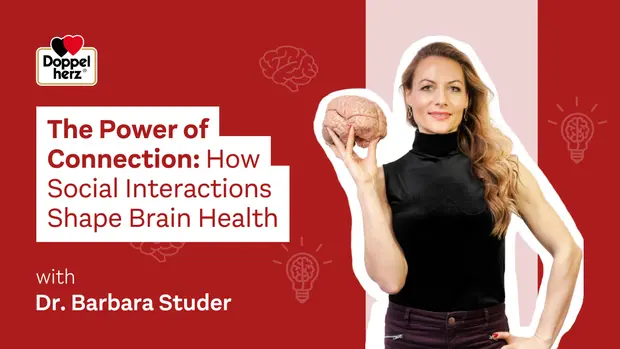 En kvinde står med en hjernemodel i hånden og ser direkte ind i kameraet. Hun bærer en sort top og har langt hår. Over hende står teksten "The Power of Connection: How Social Interactions Shape Brain Health" med hendes navn, Dr. Barbara Studer, angivet.